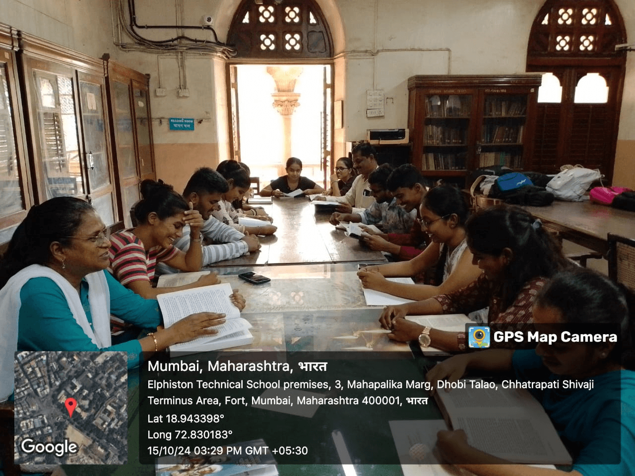 Faculty and student-teachers reading together in the college library for Vachan Prerna Din